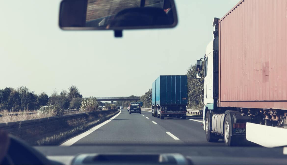 View from inside a car of two 18-wheelers ahead - Texas personal injury lawyers for highway accidents