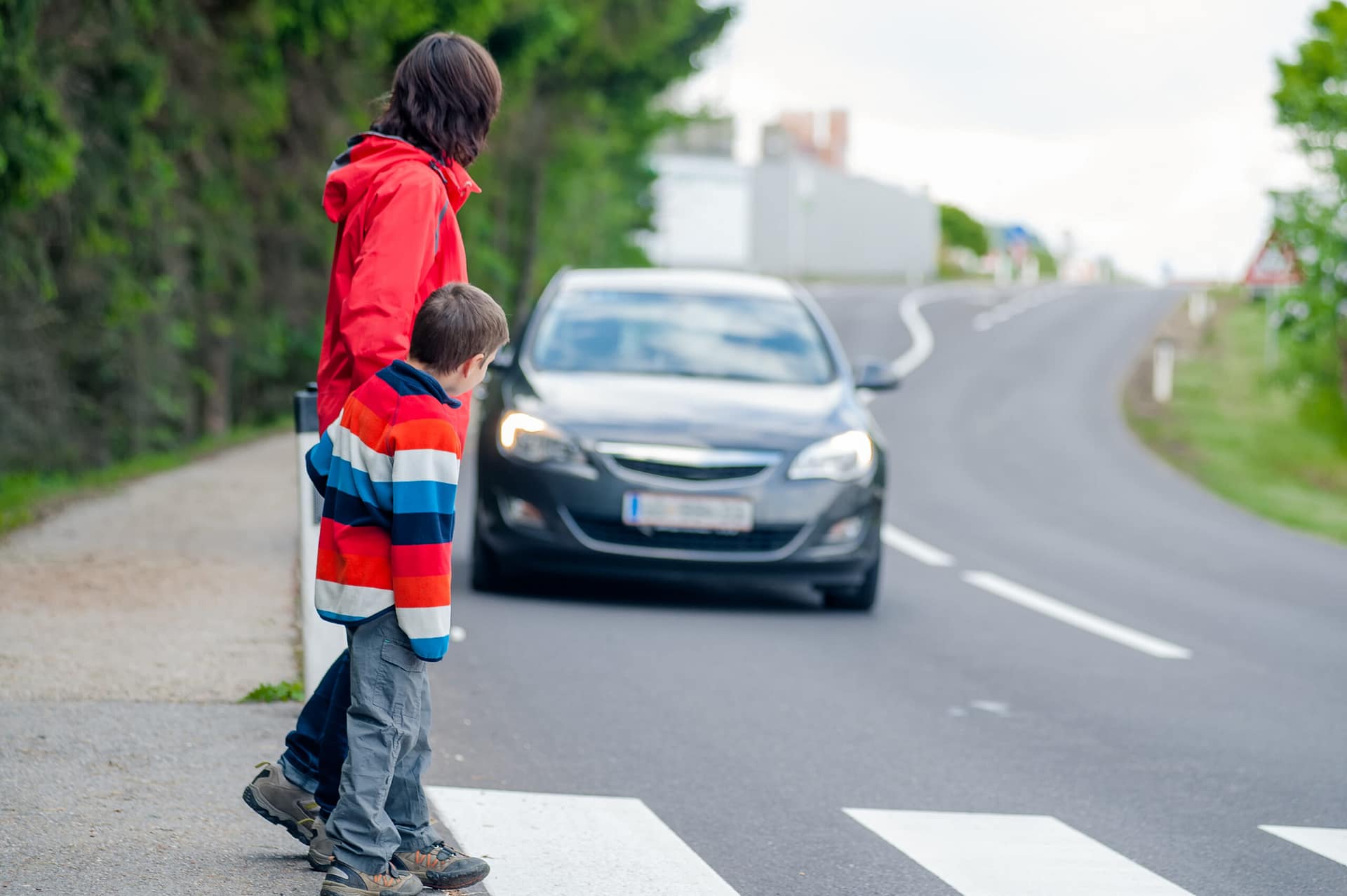 Car driving toward pedestrians crossing crosswalk.- pedestrian accident lawyer