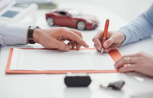 Cobertura mínima de seguro para autos financiados en Texas 3 Conductor firmando un seguro de automóvil