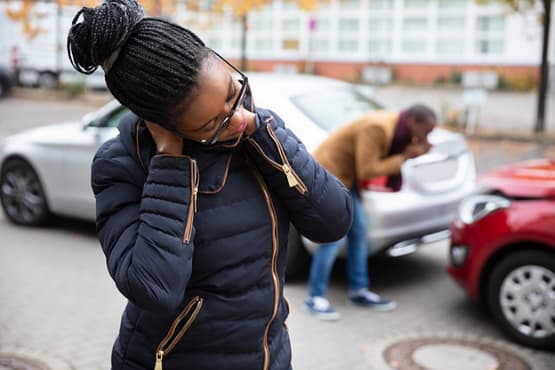 How to Calculate Pain and Suffering Damages in Texas 2 Woman holding her neck with a rear-end accident in the background. How to Calculate Pain and Suffering Damages in Texas