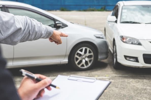 How is Fault Determined in a Car Accident in Texas? 4 Man pointing at t-bone car accident while another man takes notes. Determine fault in a Texas car accident.