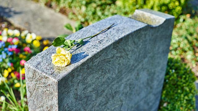 Flor amarilla colocada encima de una lápida. Abogados de muerte por negligencia en El Paso.