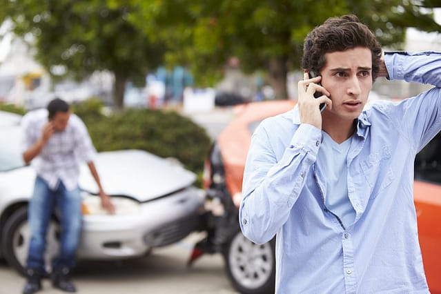 What To Do After a Car Accident: A Step-by-Step Guide (2026) 3 Driver on the phone after a car accident reporting the crash and documenting details