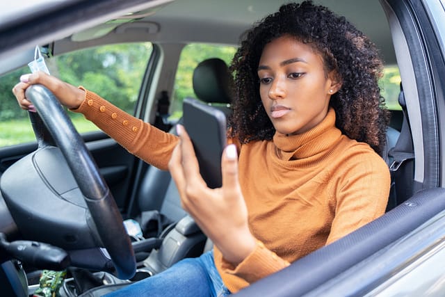 Teen Safe Driving: How Teens Can Become Safer Drivers 4 Woman driving car distracted by her mobile phone