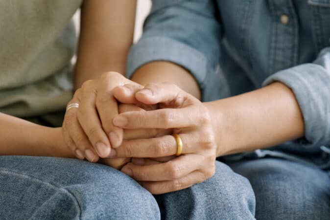 Middle aged asia people old mom holding hands trust comfort help young woman talk crying stress relief at home. Mum as friend love care hold hand adult child feel pain sad worry of life crisis issues. Personal Injury emotional toll