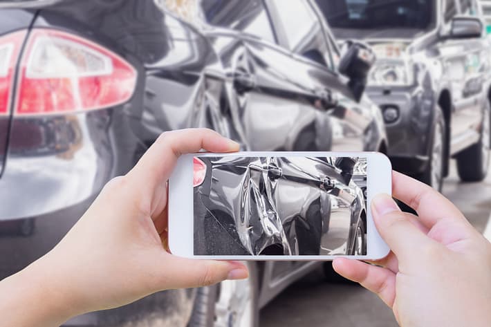 7 Reasons You Should Hire an Injury Lawyer After a Car Crash 4 Hand using mobile smart phone taking photo of the car crash accident damage for insurance. Reasons you should hire an injury lawyer